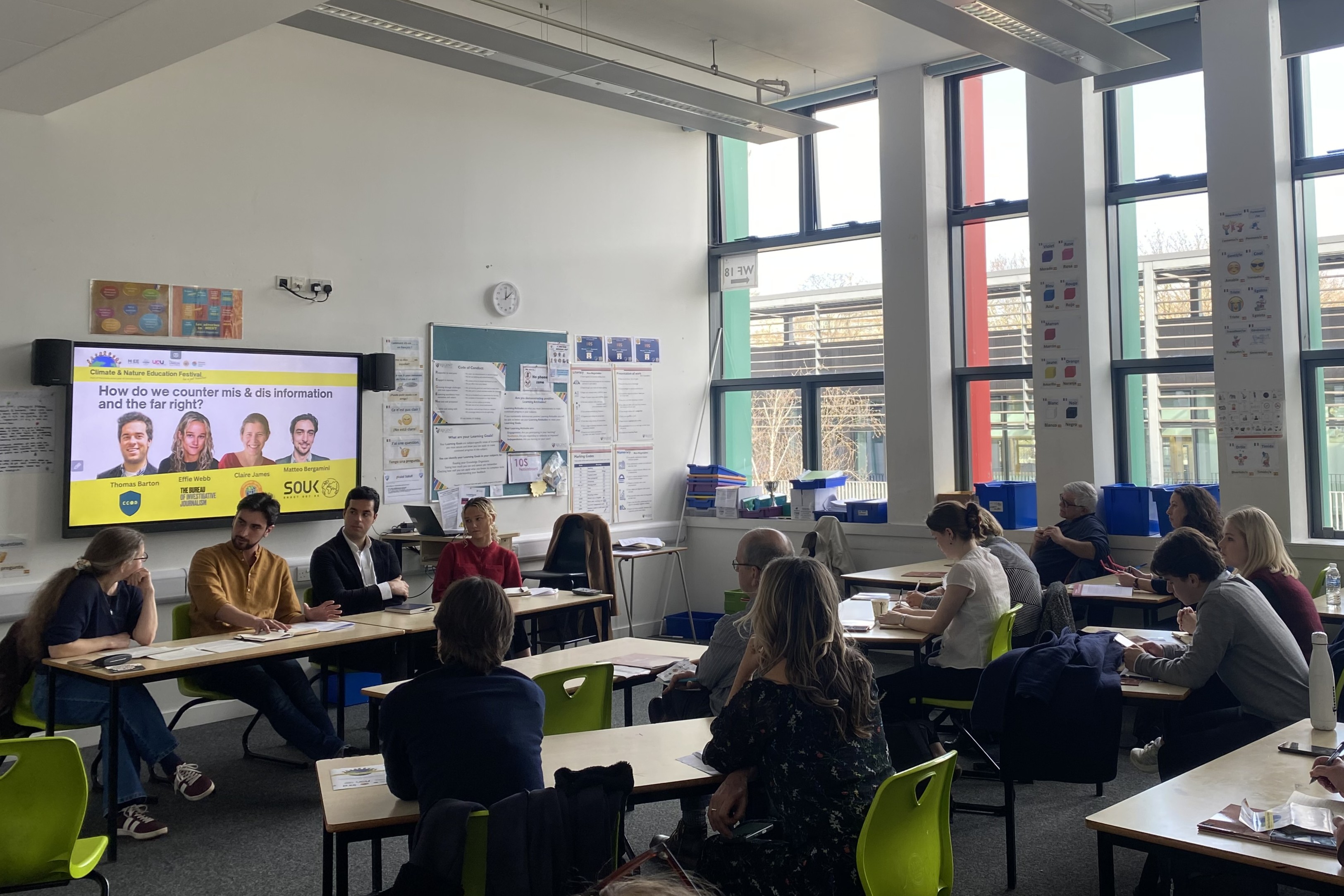 Panel of four speakers in a classroom