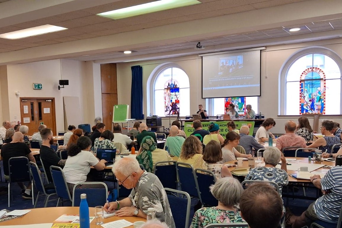 Conference, attendees sitting round tables with speakers at top table